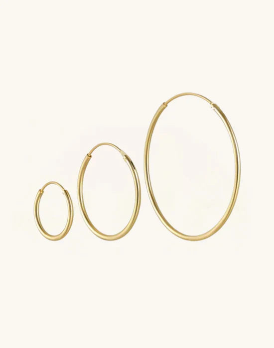 Sabina – Gold earrings with a shiny structure.