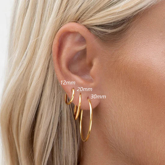 Sabina – Gold earrings with a shiny structure.