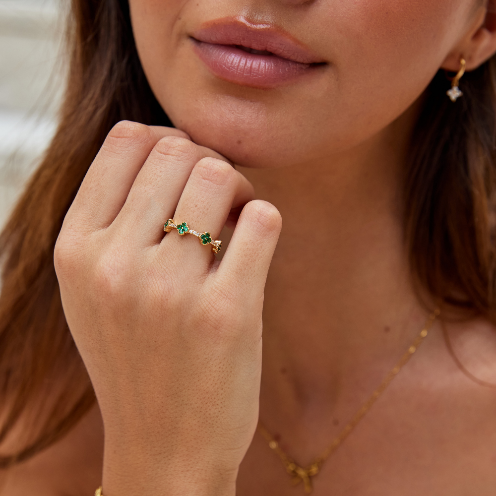 Annika – Gold-plated ring with floral details and an emerald element.