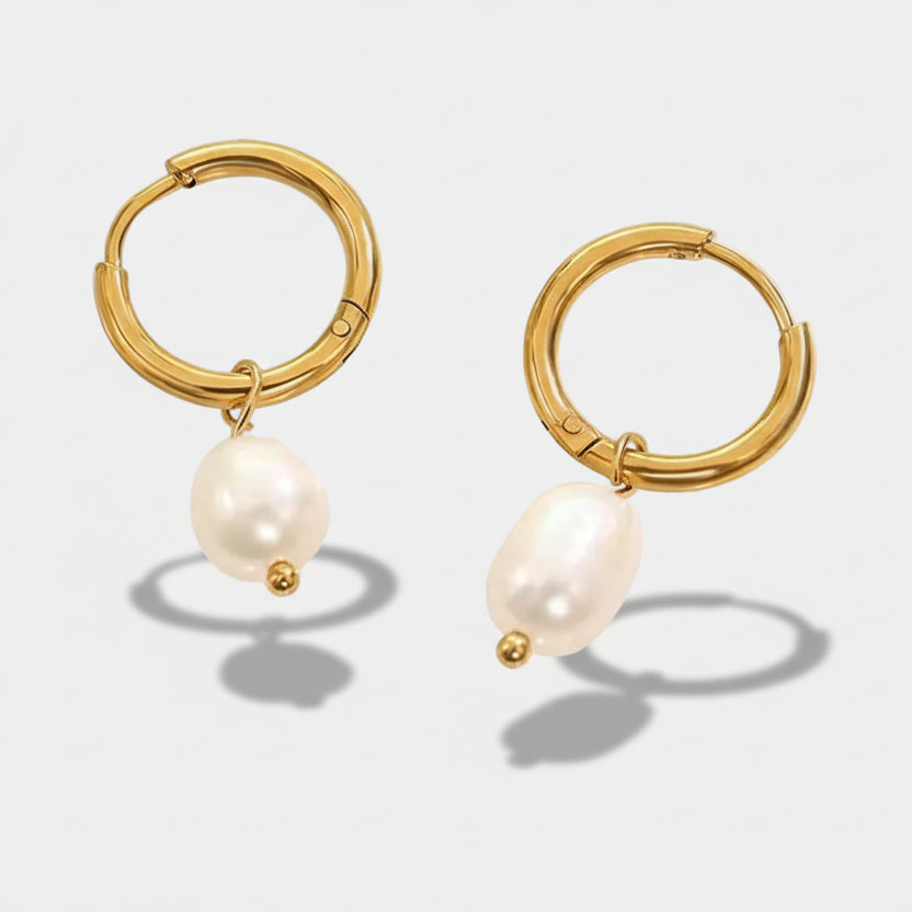 Greta-Marie – Gold earrings with dangling pearls.