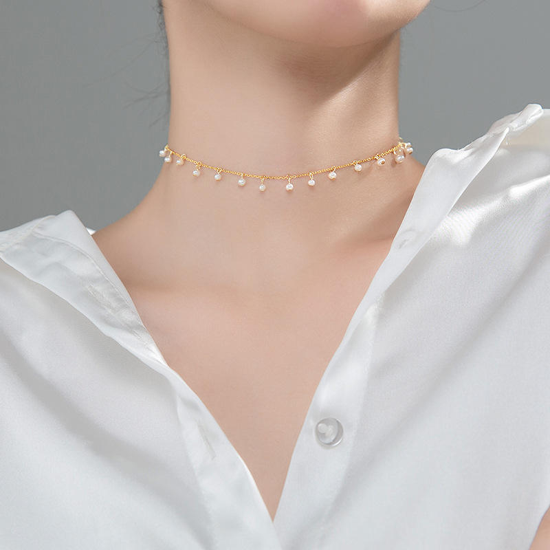 Irma – Round pearl earrings with textured gold edge.