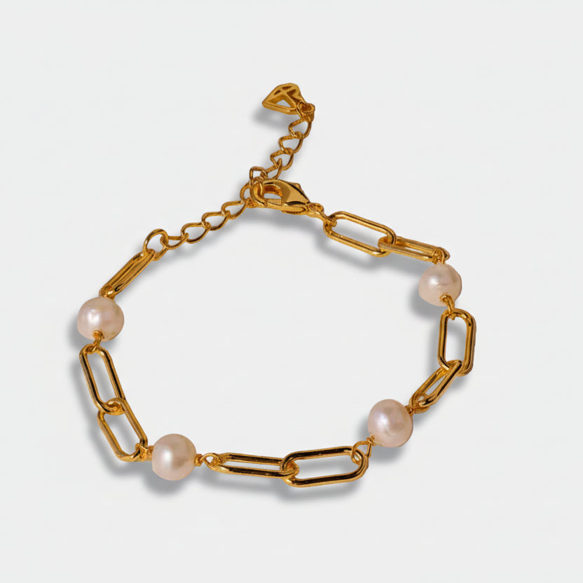 Emilie – Gold-tone pearl earrings with hook closure.