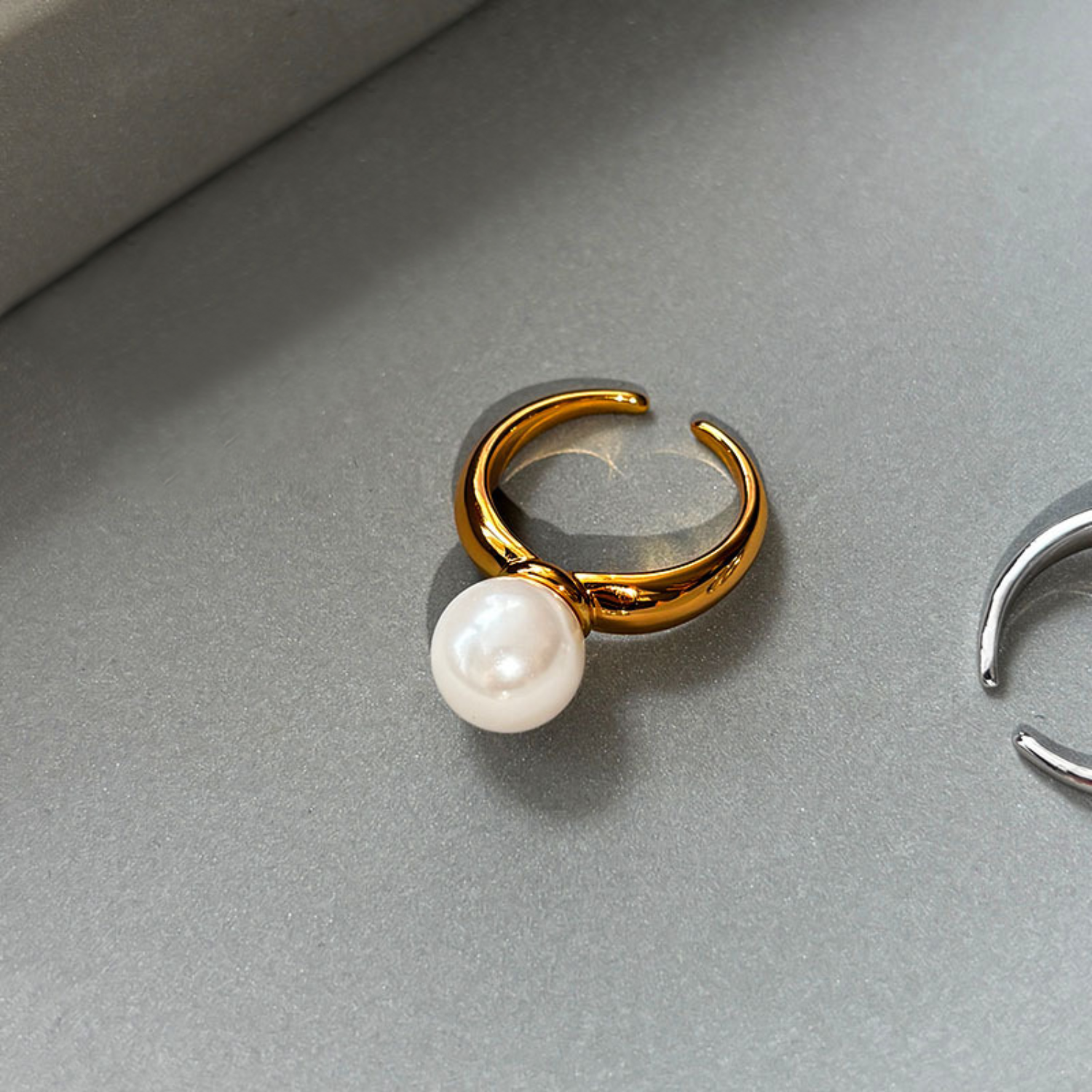 Ida – Gold-plated ring with smooth surface and pearl accent.