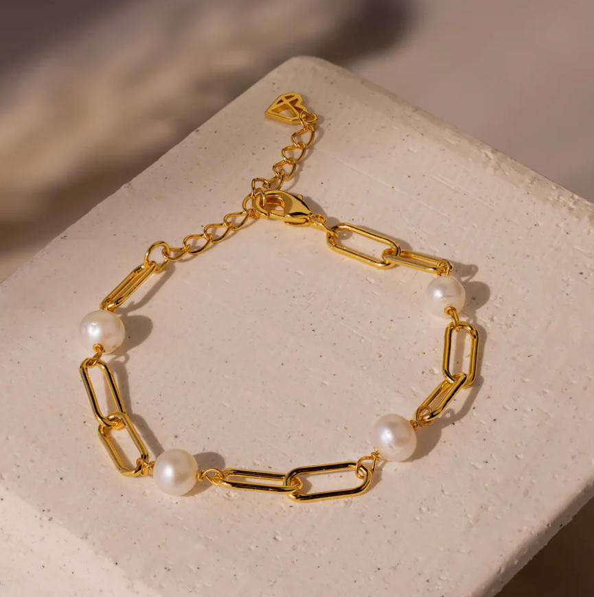 Emilie – Gold-tone pearl earrings with hook closure.
