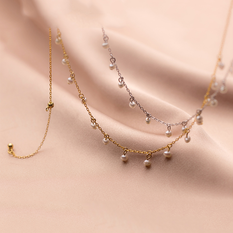 Irma – Orecchini di perle rotonde con bordo dorato strutturato.